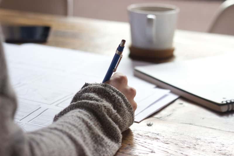 student working on a practice MCAT exam with cup of tea in background