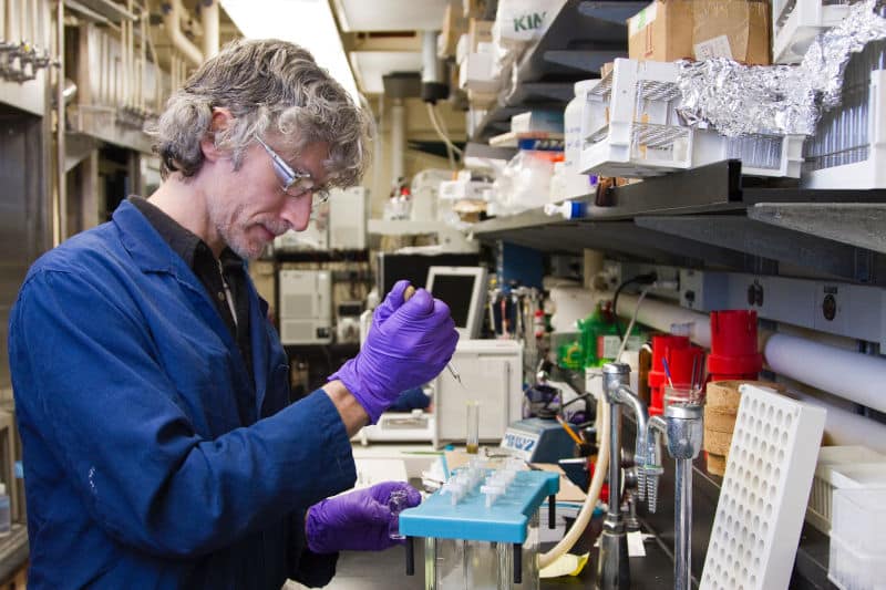 medical lab professional adding fluid to test tube