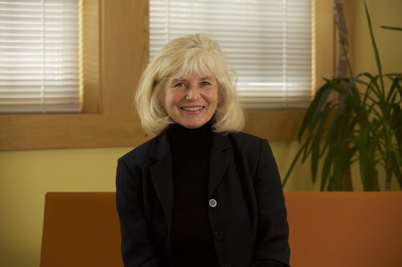 Janet Williams smiling while sitting in front of window