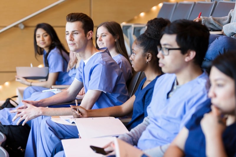 medical students sitting in auditorium diverse group of medical students attending a class in an auditorium