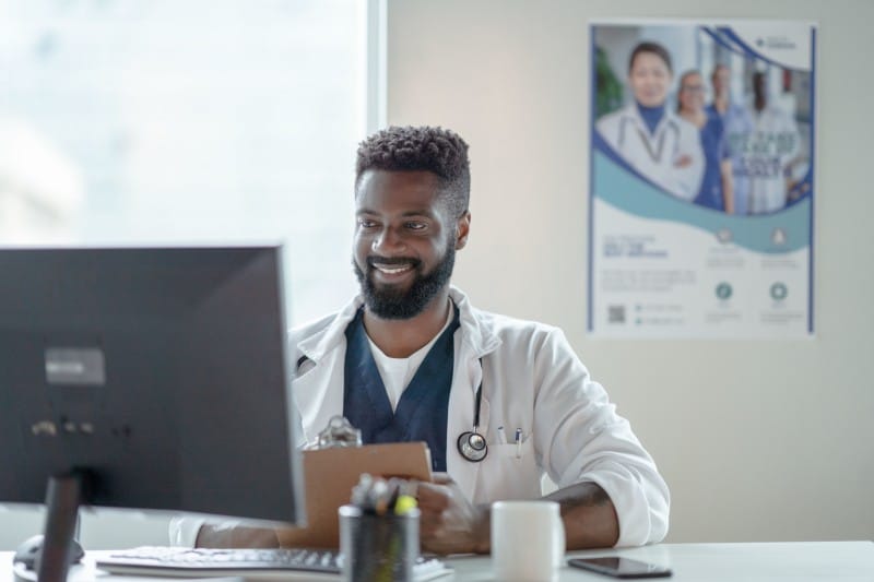 african american male assisting patients electronically via desktop computer