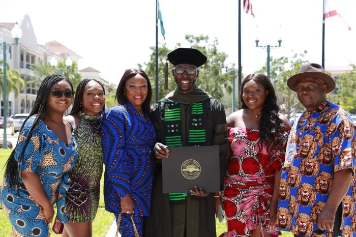 african american male graduate with friends and family members 